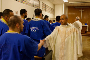Msgr. Anthony Figueiredo shakes inmates' hands following a Mass in honor of St. Carlo Acutis' relic visit to LA Men’s Central Jail on Oct. 20. (Reese Cuevas)
