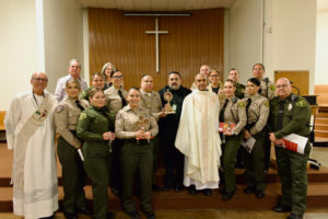 Msgr. Anthony Figueiredo, center, right, poses with sheriff's deputies and staff during St. Carlo Acutis' relic visit to LA Men’s Central Jail on Oct. 20. (Reese Cuevas)