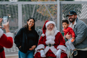Volunteers pose for photos with Santa during the annual Adopt-a-Family LA  gift distribution event on Dec. 13 at the Cathedral of Our Lady of the Angels. (Peter Lobato)