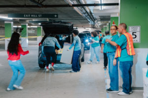 Volunteers carry donations of gifts, clothing, and more during the annual Adopt-a-Family LA  distribution event on Dec. 13 at the Cathedral of Our Lady of the Angels. (Peter Lobato)