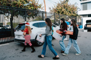 Volunteers carry donations of gifts, clothing, and more during the annual Adopt-a-Family LA  distribution event on Dec. 13 at the Cathedral of Our Lady of the Angels. (Peter Lobato)