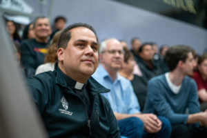 Father Peter Saucedo, left, vocations director for the Archdiocese of Los Angeles, watches as the Capuchin Franciscans play against the LA seminarians on Jan. 18 at St. Francis High School in La Cañada Flintridge. (John Rueda)