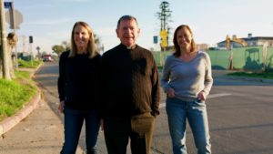 From left: Sue Kohl, Msgr. Liam Kidney, and Paola Sessarego during a visit to the site of Corpus Christi Church in Pacific Palisades in Dec. 2025. Behind them are multiple rebuilt homes under construction.(Reese Cuevas)
