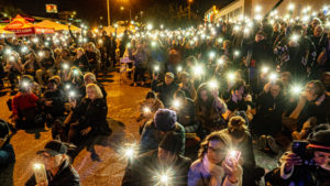 Community members turn on their cellphone flashlights to commemorate the 19 lives lost in the Eaton Fire during an interfaith ceremony in Altadena on Jan. 7, 2026. (Juanito Holandez Jr.)