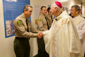 Auxiliary Bishop Matt Elshoff greets sheriff's deputies as he celebrated Christmas Day Mass with inmates at Men’s Central Jail near downtown LA. (Reese Cuevas)