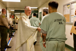 Auxiliary Bishop Matt Elshoff greets inmates as he celebrated Christmas Day Mass at Men’s Central Jail near downtown LA. (Reese Cuevas)