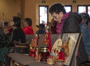 Rosalina Adrineda of Carson, right, prays during the blessing ceremony at a Santo Niño Mass and Sinulog festival held at St. Philomena Church in Carson on Jan. 17. (Juanito Holandez Jr.)