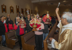 Father Lester Avestruz blesses the Santo Niño statues during a Mass and Sinulog festival held at St. Philomena Church in Carson on Jan. 17. (Juanito Holandez Jr.)