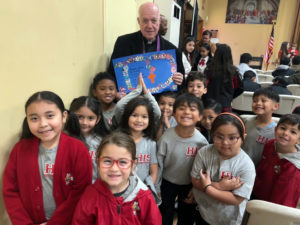Holly Innocents School students pose with Father Peter Irving III, pastor at Holy Innocents Church, during Catholic Schools Week celebrations. (Holy Innocents School)