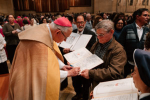 Archbishop José  H. Gomez signs a parish’s Book of the Elect during the Rite of Election ceremony at the Cathedral of Our Lady of the Angels on Feb. 15. (Peter Lobato)