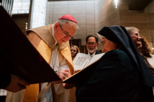 Archbishop José  H. Gomez signs a parish’s Book of the Elect during the Rite of Election ceremony at the Cathedral of Our Lady of the Angels on Feb. 15. (Peter Lobato)