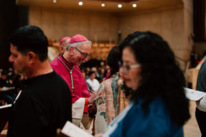 Auxiliary Bishop Marc Trudeau signs a parish’s Book of the Elect during the Rite of Election ceremony at the Cathedral of Our Lady of the Angels on Feb. 15. (Peter Lobato)