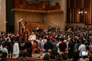 Archbishop José  H. Gomez stands in the throng of catechists and catechumens on the altar with the Book of the Elect during the Rite of Election ceremony at the Cathedral of Our Lady of the Angels on Feb. 15. (Peter Lobato)