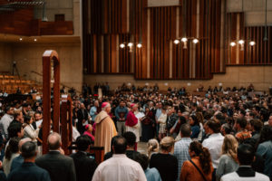 Archbishop José  H. Gomez stands in the throng of catechists and catechumens on the altar with the Book of the Elect during the Rite of Election ceremony at the Cathedral of Our Lady of the Angels on Feb. 15. (Peter Lobato)