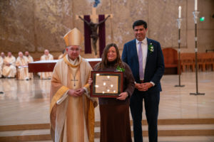 Archbishop José H. Gomez and Paul Escala, superintendent of LA Catholic schools, pose with St. Joseph High School's Dereka Anderson at the 2026 Christian Service Awards Mass on March 10 at the Cathedral of Our Lady of the Angels. (John Rueda)