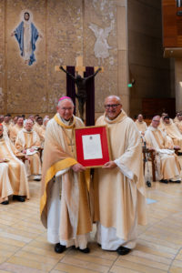 Father Jim Anguiano, right, presents Archbishop José H. Gomez with a message and apostolic blessing from Pope Leo XIV presented at the end of the March 26 Mass at the Cathedral of Our Lady of the Angels celebrating his 25th anniversary of episcopal consecration. (Isabel Cacho)