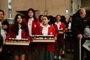 Volunteer students carry in the holy oils to be blessed at the Cathedral of Our Lady of the Angels during the Chrism Mass on March 30. (Peter Lobato)