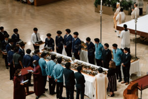 Volunteer students carry in the holy oils to be blessed at the Cathedral of Our Lady of the Angels during the Chrism Mass on March 30. (Peter Lobato)