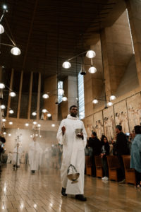 Seminarian Christian Eguaroje helps lead the procession into the Cathedral of Our Lady of the Angels during the Chrism Mass on March 30. (Peter Lobato)
