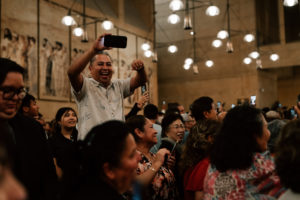 Attendees take photos and videos during the priests' procession into the Cathedral of Our Lady of the Angels during the Chrism Mass on March 30. (Peter Lobato)