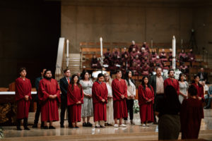 Those preparing to be baptized into the Catholic Church stand on the altar during the Easter Vigil at the Cathedral of Our Lady of the Angels on April 4. (Peter Lobato)
