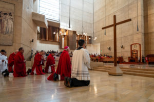 Archbishop José H. Gomez and other priests kneel in front of the cross during the Good Friday liturgy at the Cathedral of Our Lady of the Angels on April 3. (Reese Cuevas)