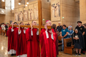 Archbishop José H. Gomez helps lead the carrying of the cross during the Good Friday liturgy at the Cathedral of Our Lady of the Angels on April 3. (Reese Cuevas)