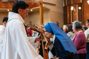 A religious sister kisses the cross during the Good Friday liturgy at the Cathedral of Our Lady of the Angels on April 3. (Reese Cuevas)