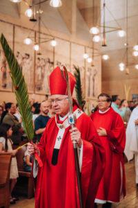 Archbishop José H. Gomez carries a palm as he processes into the Cathedral of Our Lady of the Angels to celebrate the Palm Sunday Mass on March 29. (Isabel Cacho)