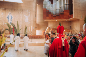 Archbishop José H. Gomez carries a palm as he processes into the Cathedral of Our Lady of the Angels to celebrate the Palm Sunday Mass on March 29. (Isabel Cacho)