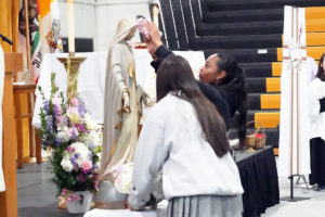 Students at Bishop Montgomery High School in Torrance crown their Virgin Mary statue during a May crowning ceremony at the school. (Bishop Montgomery High School)