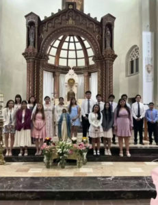 Students at Immaculate Conception School in Los Angeles pose around a crowned statue of the Virgin Mary during a May crowning ceremony. (Immaculate Conception School)