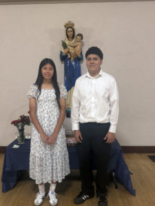 Eighth-graders Sophia Diaz and Emmanuel Mendoza at Notre Dame School in Santa Barbara pose with the crowned Virgin Mary statue during a May crowning event. (Notre Dame School)