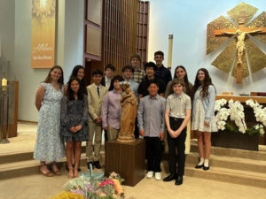 Students at St. Martin of Tours School in Brentwood pose around a crowned statue of the Virgin Mary during a May crowning ceremony. (St. Martin of Tours School)