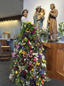 Amani Diaz, a student at St. Raphael School in Santa Barbara, crowns a statue of the Virgin Mary during a May crowning event. (St. Raphael School)
