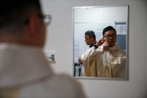 Father Shengda (Martin) Zhu prepares for his first Mass at his home parish of St. Thomas Aquinas Church in Monterey Park on May 31. (John Rueda)