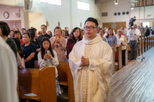 Father Shengda (Martin) Zhu processes in during his first Mass at his home parish of St. Thomas Aquinas Church in Monterey Park on May 31. (John Rueda)