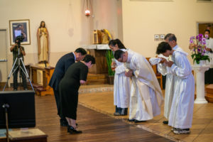 Father Shengda (Martin) Zhu bows to his parents, who brought up the Communion gifts, during his first Mass at his home parish of St. Thomas Aquinas Church in Monterey Park on May 31. (John Rueda)