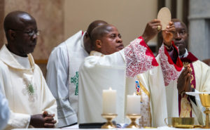 Cardinal Peter Ebere Okpaleke of Ekwulobia, Nigeria, holds the body of Christ during a special May 31 Mass at St. Eugene Church in South LA. The cardinal visited LA as part of a tour visiting Nigerian Catholics living in the U.S. (Michael Goulding)
