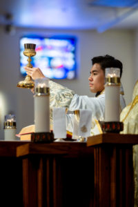 Father Jerick Alenton holds up the blood of Christ during his first Mass at his home parish of St. Clare of Assisi Church in Santa Clarita on May 31. (Joe Garcia III)