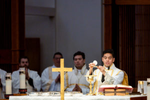 Father Jerick Alenton holds up the body of Christ during his first Mass at his home parish of St. Clare of Assisi Church in Santa Clarita on May 31. (Joe Garcia III)