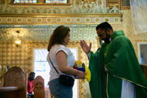 Venezuelan priest Father Alexander Hernandez, CSsR, blesses gifts during a Mass for victims of the Venezuela earthquakes Sunday, June 28, at Nuestra Señora de Guadalupe Church in East LA. (John Geronilla)