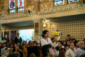 A young lady takes up a gift to be blessed during a special Mass at Nuestra Señora de Guadalupe Church in East LA on Sunday, June 28, to pray for victims of the Venezuela earthquakes. (John Geronilla)