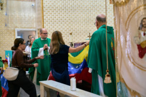 Parishioners add a Venezuelan flag to the altar during a special Mass at Nuestra Señora de Guadalupe Church in East LA on Sunday, June 28, to pray for victims of the Venezuela earthquakes. (John Geronilla)