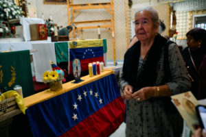 A parishioner passes the Venezuelan flag during a special Mass at Nuestra Señora de Guadalupe Church in East LA on Sunday, June 28, to pray for victims of the Venezuela earthquakes. (John Geronilla)