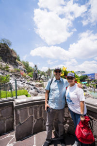 A couple of pilgrims from the LA Archdiocese pose at Tepeyac, where statues mark the place Our Lady of Guadalupe appeared to St. Juan Diego. (Isabel Cacho)
