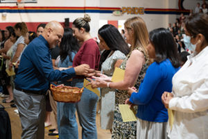 The Department of Schools' Erick Rubalcava hands out catechist pins during the Welcome Back Mass on Aug. 5 at Cantwell-Sacred Heart of Mary High School in Montebello. (Poncho Romero)