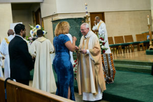 Archbishop José H. Gomez greets a loved one during the Aug. 14 funeral Mass for Deacon Hosea Alexander at Holy Name of Jesus Church in Los Angeles. (John Geronilla)