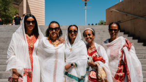 Attendees dressed in cultural, ethnic, and religious clothing pose following in the 