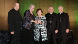Marge Graf, general counsel for the Archdiocese of Los Angeles, accepts the Evangelii Gaudium Award from Heather Banis and Archbishop José H. Gomez Sept. 19. Also pictured are Bishop Matthew Elshoff (right), who served as the event’s master of ceremonies; and Father Leon Hutton, rector of St. John’s Seminary in Camarillo. (Belle N’ Beau Photography)